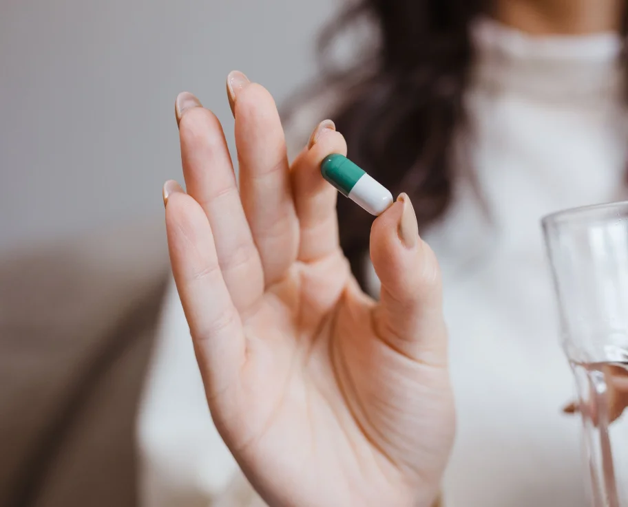 Hand holding a single small capsule