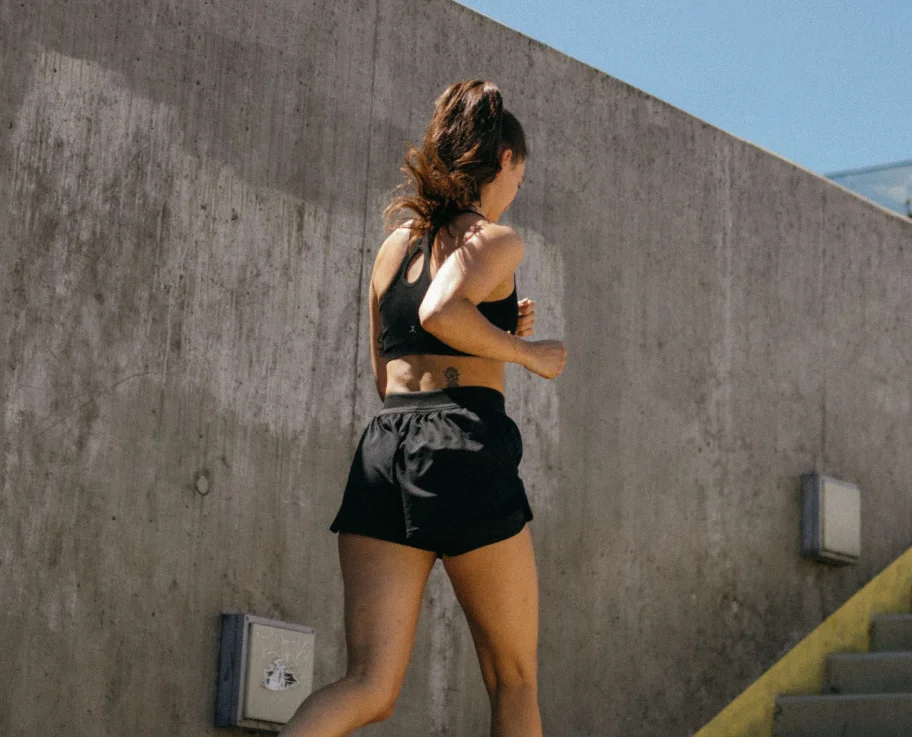 Woman running up outdoor stairs