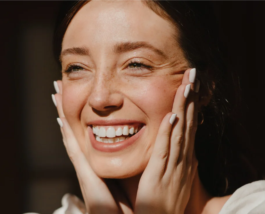Close-up of a smiling woman with glowing skin